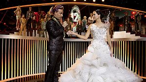 Caesar Flickerman (Stanley Tucci, links) und Katniss Everdeen (Jennifer Lawrence, rechts) bei der Show vor dem Todeskampf. © 2014 Lions Gate Entertainment Inc.