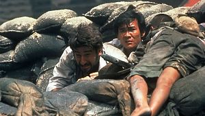 Der US-Journalist (Sam Waterston) und sein kambodschanischer Kollege Dith Pran (Haing S. Ngor) verstecken sich zwischen Leichen und Sandsäcken vor den Roten Khmer. © ©1984 GOLDCREST FILMS AND TELEVISION LTD. ALL RIGHTS RESERVED.